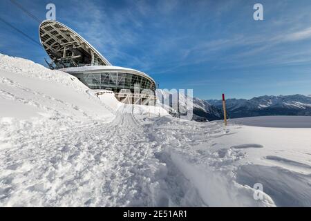 Wide angle view of the middle ropeway station on the Italian side of Mont Blanc, surrounded by snow under a blue sky with sparse clouds Stock Photo
