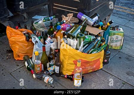 Empty glass bottles left beside bins on Leith Walk, Edinburgh, Scotland, UK. Stock Photo