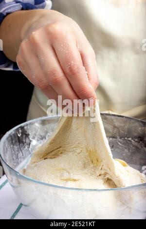 The baker kneads the bread dough. Rustic dough kneading. Stock Photo