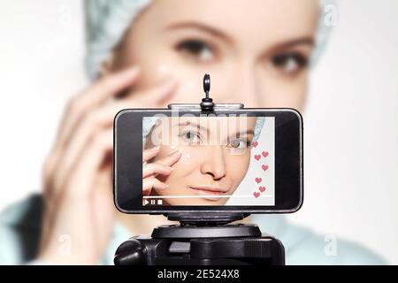 Woman Beauty Vlogger. Video Clip by Smartphone Sharing on Social Media. Fashion Blogger Applying Beauty Eye Cream. Daily Morning Face Care Routine for Stock Photo