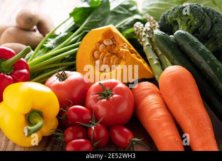 Many kinds of fresh vegetables placed on a wooden background Stock Photo