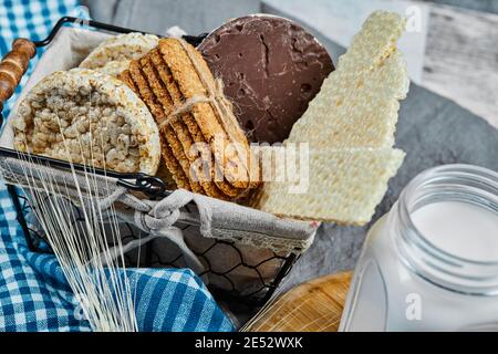 Basket of biscuits and a jar of milk on a marble table, close up Stock Photo