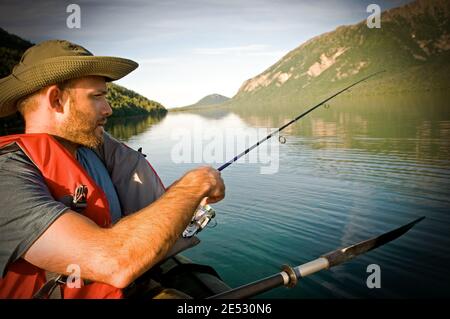 Fishing off a canoe on the Kijik Lake in Lake Clark National Park, Alaska. Stock Photo