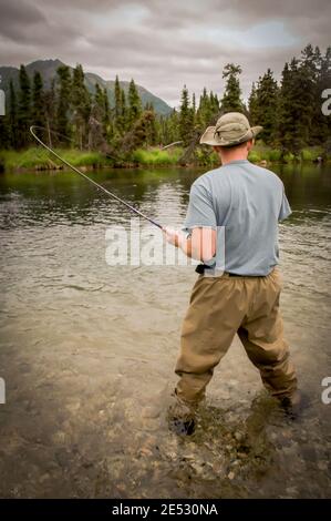 Reeling in a Salmon catch on Lake Kijik near Lake Clark National Park Alaska. Stock Photo