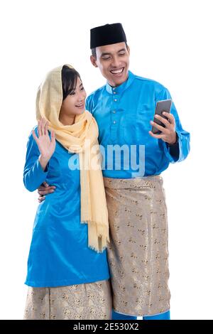 muslim couple using mobile phone isolated over white background Stock Photo