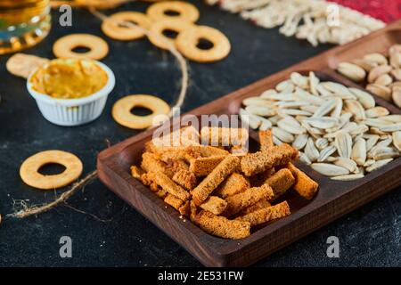 Plate of assorted snacks and crackers on dark table Stock Photo