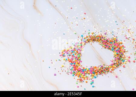 Heart shape made from small colorful candies on a white marble background. Valentine day. About love. High quality photo Stock Photo