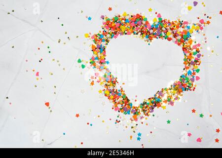 Heart shape made from small colorful candies on a white marble background. Valentine day. About love. High quality photo Stock Photo