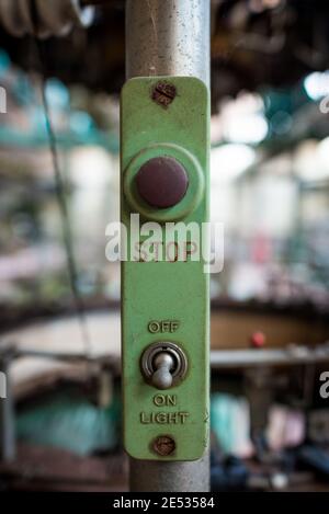 Symmetrical close up of the emergency stop button on an industrial machine in an abandoned Italian textile company Stock Photo