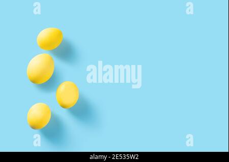 yellow easter eggs on blue background. Beautiful yellow eggs isolated on blue with copy space. easter greeting card. Happy Easter Stock Photo