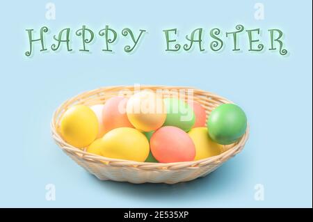Close up of colorful Easter eggs in basket. happy easter text. Colorful handmade easter eggs in the basket Stock Photo