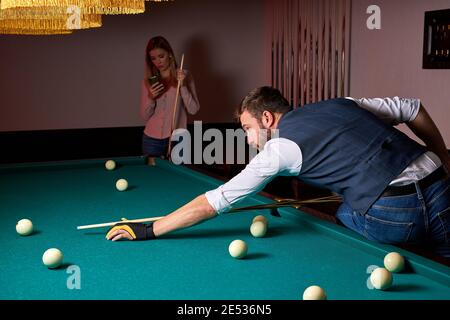 male billiard player finding best solution and right angle at billard or snooker pool sport game, professional billiard player is concentrated Stock Photo