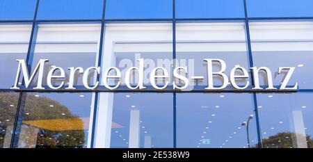 Mercedes Benz sign on a local dealership building windows. Stock Photo