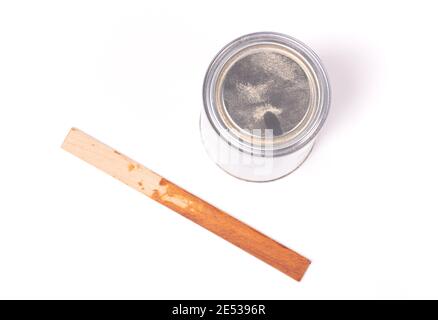 Old stirring stick with a pot of paint, isolated on white Stock Photo