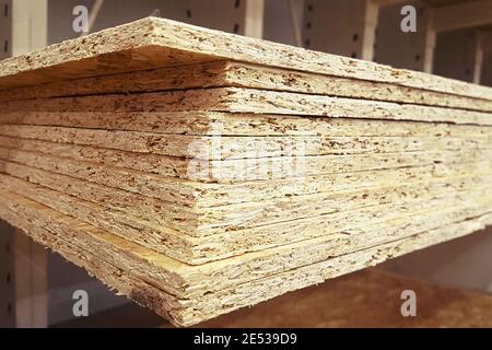 A stack of OSB sheets stacked is sold at the supermarket in the warehouse. Stock Photo