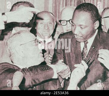 President Lyndon Johnson shakes hands with Reverend Martin Luther King, Jr., on July 3, 1964 in Washington, District of Columbia, after handing him a Stock Photo