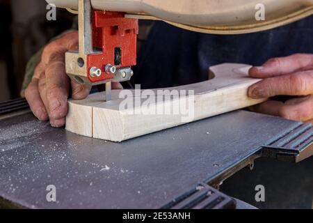 Close-up worker hands in the carpentry workshop cuts the log into boards using band saw. Raw wood and wooden crafts Stock Photo