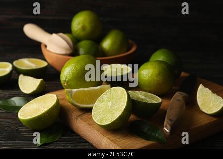 Bowl and board with lime on wooden background Stock Photo