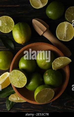 Bowl with ripe lime on wooden background, top view Stock Photo