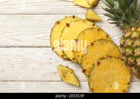 Pineapple and slices on white wooden background Stock Photo