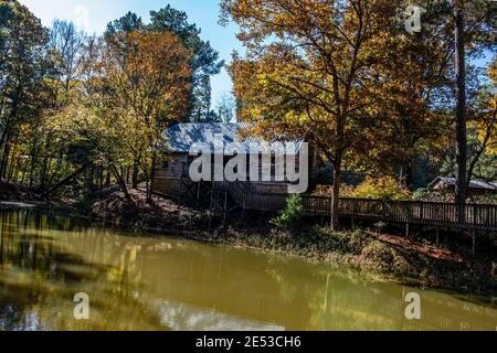 Bethel, Alabama/USA-November 10, 2018: A period log cabin beside a mill pond at the Clarkson Covered Bridge and Park in Cullman County. Stock Photo