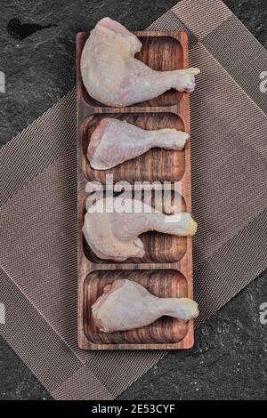 Raw chicken legs on wooden plate Stock Photo