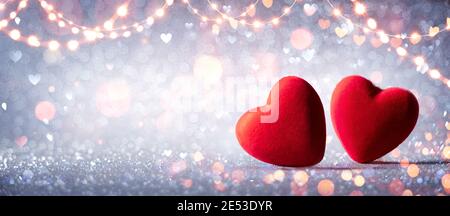 Two Hearts In Love On Silver Glitter With Abstract Defocused Background Stock Photo