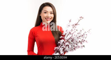 Young Asian woman in traditional vietnamese red dress with peach blossom flowers Lunar new year's Stock Photo