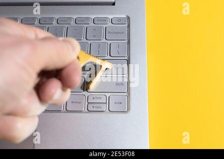 man using contactless tool to press laptop button and prevent spread of Covid. Stock Photo
