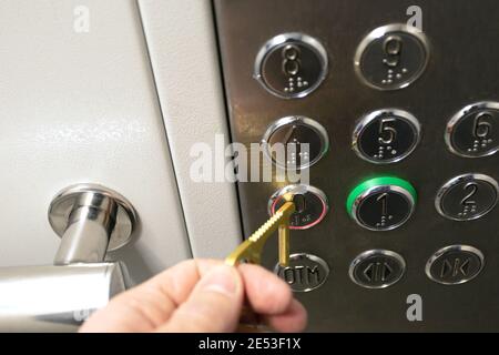 man using contactless tool to press elevator button. prevent spread of COVID Stock Photo