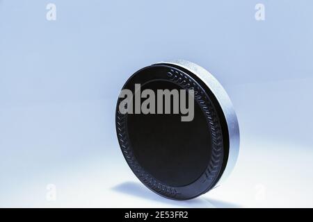 Flat metal box with black lid and silver base standing on end. Stock Photo