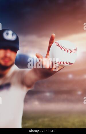 Baseball pitcher throws the ball - serve in the game against the background of the stadium defocus - focus on the flying ball Stock Photo