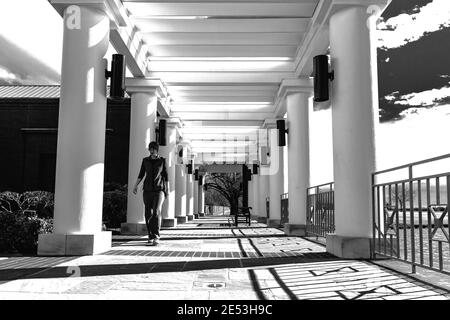 Montgomery, Alabama, USA - January 28, 2017: Woman walks through the open veranda at the Montgomery Museum of Fine Arts on a brisk winter day in black Stock Photo