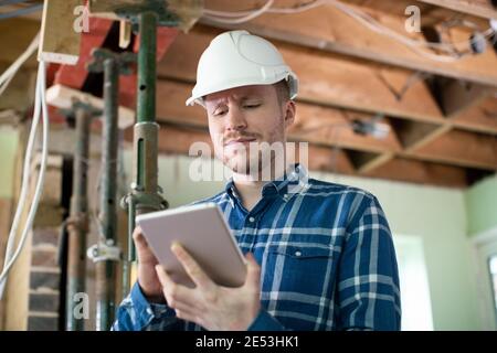 Architect Inside House Being Renovated Using Digital Tablet Stock Photo