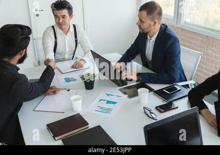 Young business people working and communicating while sitting at the office desk together with colleagues sitting. business meeting Stock Photo