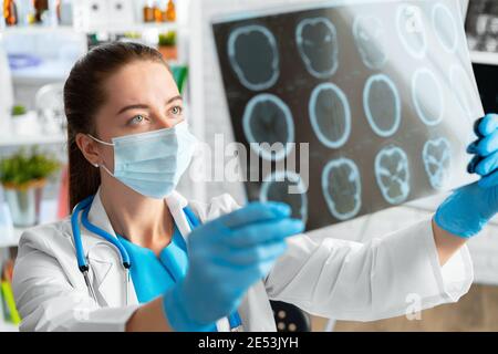 Woman doctor examines head mri scan in hospital Stock Photo