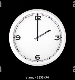 White round analog wall clock isolated on black background, its two oclock. Stock Photo