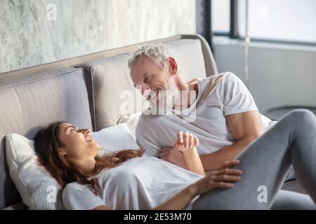 Man and woman lying on bed communicating Stock Photo