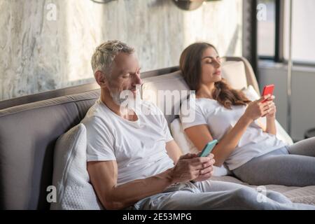 Husband and wife staring at their smartphones Stock Photo
