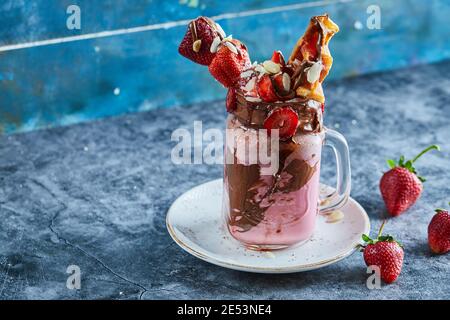 Strawberry smoothie with waffles and chocolate on the white plate in the marble background Stock Photo