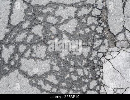 Asphalt road with small rocks and cracks. Stock Photo
