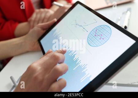 Businessman holding tablet with charts and diagrams in his hands at workplace Stock Photo