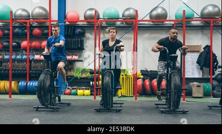 Athletes doing air bike indoor Stock Photo