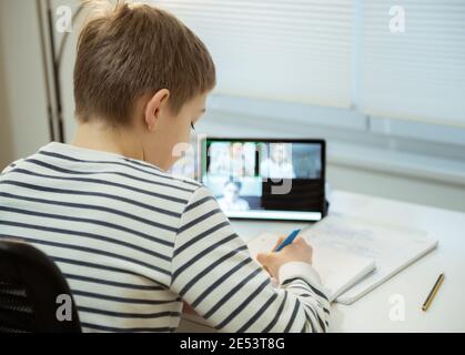 Teenager school boy having virtual lesson at home using tablet during homeschooling at pandemic quarantine Stock Photo