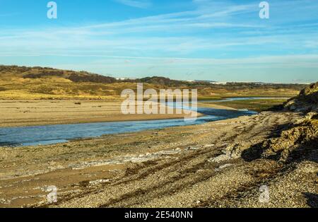 The River Ogmore at Ogmore by Sea heading out to sea, in the Vale of Glamorgan, south Wales on a sunny January day. Stock Photo