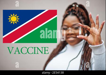 African woman show vaccine for Republic of Namibia. Vaccination of Africa countries concept. Stock Photo