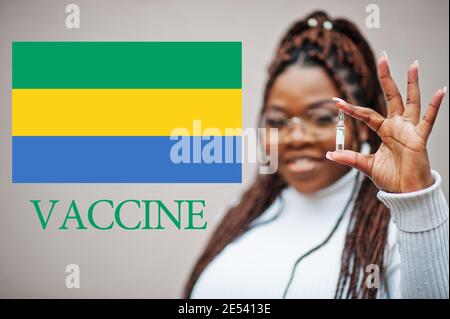 African woman show vaccine for Gabonese Republic. Vaccination of Africa countries concept. Stock Photo