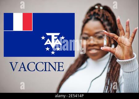 African woman show vaccine for French Southern and Antarctic Lands. Vaccination of Africa countries concept. Stock Photo