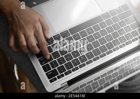 Top View. Finger pressing Enter key, Working on computer notebook. Stock Photo