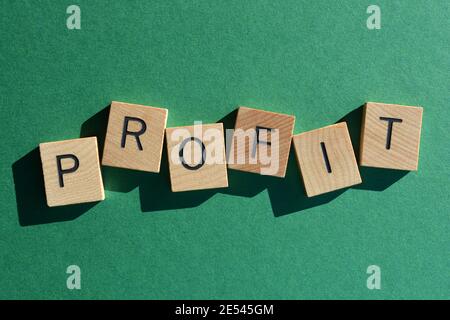 Profit, word in wooden alphabet letters isolated on green background Stock Photo